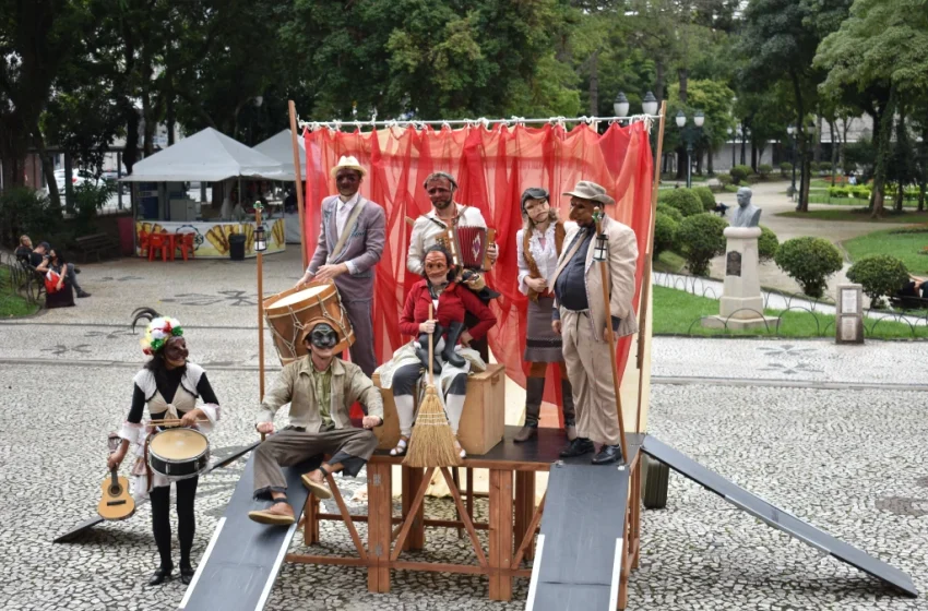  À espera do ônibus, elenco invade a Praça Santos Andrade